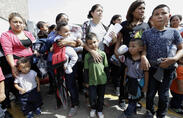 Immigrant women and children wait to enter the bus station.