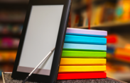 Stock photo of rainbow notebooks and tablet.