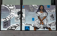 Mural of two people with racial justice imagery and phrases