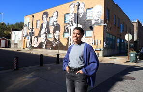 A Facing History alumni stands in front of the Memphis Upsdanders Mural.