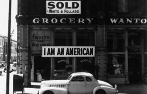 Sign on a grocery store in Oakland, California that reads "I am an American."  This is a historic image taken in 1943.