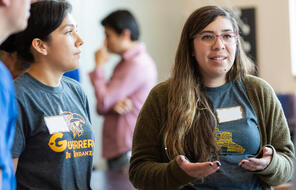 High School student and teacher speaking at a workshop.