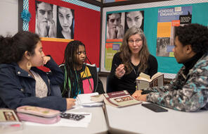 educator speaking while three students sit and listen