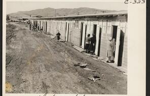 This center is a converted race track. Here are shown what were horse-stalls, now remodeled into living quarters for families. Photograph was made at noon on the third day after the center had been opened. 