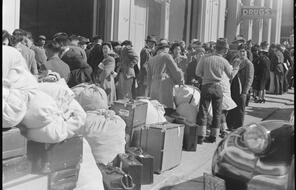 With baggage stacked, residents of Japanese ancestry await bus at Wartime Civil Control Administration station, 2020 Van Ness Avenue, as part of the first group of 664 to be evacuated from San Francisco on April 6, 1942. Evacuees will be housed in War Relocation Authority centers for the duration.