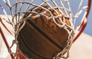 a basketball shot through a white basketball net