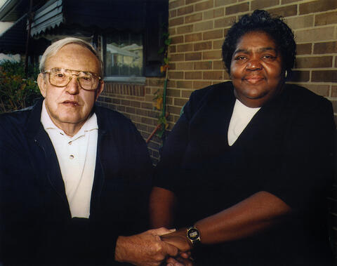 C.P. Ellis, a white man, and Ann Atwater, a Black woman, sit together holding hands.