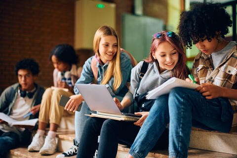 Group of high school students cooperate while learning together at school