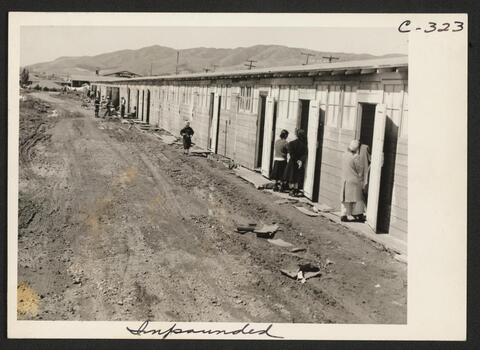 This center is a converted race track. Here are shown what were horse-stalls, now remodeled into living quarters for families. Photograph was made at noon on the third day after the center had been opened. 