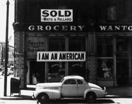 Sign on a grocery store in Oakland, California that reads "I am an American."  This is a historic image taken in 1943.